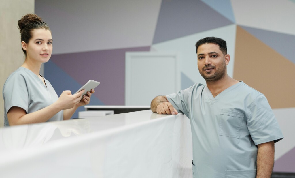 Medical staff members in scrub suits at a modern clinic's reception area.